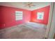 Bright bedroom with pink walls, carpeted floor, and two windows offering natural light at 11 Tamiami Way, Kissimmee, FL 34758