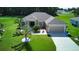 One-story house with beige exterior, two-car garage, and green lawn at 1067 Snively Cir, Lake Hamilton, FL 33851