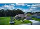 Single-story house with a beige exterior, two-car garage, and lush landscaping at 1067 Snively Cir, Lake Hamilton, FL 33851