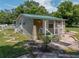Tan house with green metal roof and small porch at 14813 Camp Mack Rd, Lake Wales, FL 33898