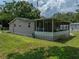 Tan house with screened porch and green yard at 14813 Camp Mack Rd, Lake Wales, FL 33898