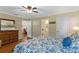 Comfortable main bedroom with a view into the ensuite bathroom, wooden dresser and floral bedding at 1521 Oakview Se Cir, Winter Haven, FL 33880