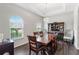 Elegant dining room with large windows, a stylish light fixture, and a dark wood dining table at 329 Lake Vista Dr, Auburndale, FL 33823