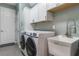 Laundry room with front-loading washer and dryer, utility sink, and cabinets at 329 Lake Vista Dr, Auburndale, FL 33823
