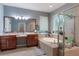 Main bathroom with double vanity, soaking tub, glass-enclosed shower, and window at 329 Lake Vista Dr, Auburndale, FL 33823