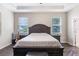 Main bedroom featuring a king-size bed, two nightstands, and large windows at 329 Lake Vista Dr, Auburndale, FL 33823