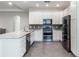 White kitchen cabinets, granite countertops, stainless steel appliances, and tile flooring at 329 Lake Vista Dr, Auburndale, FL 33823