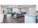 Spacious living room with hardwood floors, gray sectional sofa, and access to the backyard patio at 329 Lake Vista Dr, Auburndale, FL 33823