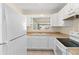 Renovated kitchen with white cabinets, modern appliances, and tile flooring at 1165 E Church St, Bartow, FL 33830
