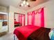 Bright bedroom with mirrored closet doors and red bedding at 902 Charo Pkwy # 624, Davenport, FL 33897