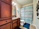 Bathroom with wood vanity, shower/tub combo, and teal decor at 902 Charo Pkwy # 624, Davenport, FL 33897