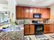 Well-equipped kitchen featuring dark wood cabinets and granite countertops at 902 Charo Pkwy # 624, Davenport, FL 33897