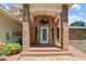 Inviting front entry with brick columns, arched entryway, and a white door at 121 E Lake Summit Dr, Winter Haven, FL 33884
