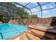 Screened-in pool and brick jacuzzi with spacious deck at 121 E Lake Summit Dr, Winter Haven, FL 33884
