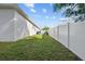 Private side yard with a grassy area and white vinyl fence at 2158 Mirasol Dr, Winter Haven, FL 33881