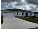 Newly built home with a two-car garage and well-maintained lawn at 177 Cimarron Ln, Kissimmee, FL 34759
