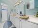 Bathroom with double vanity, shower, and light blue walls at 716 Challenger Ave, Davenport, FL 33897