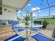 Sunroom with a glass-top table and blue chairs at 716 Challenger Ave, Davenport, FL 33897