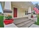 Front porch with red door, flower pots, and American flag at 816 W Hancock St, Lakeland, FL 33803