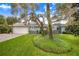 Exterior view of home with lush landscaping and a large oak tree at 2931 Chickasaw Cir, Haines City, FL 33844