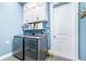 Well-equipped laundry room with stacked washer and dryer, and overhead cabinets at 2931 Chickasaw Cir, Haines City, FL 33844