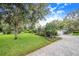 Landscaped front yard with a paved driveway and lush greenery at 2931 Chickasaw Cir, Haines City, FL 33844