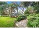 Landscaped side yard with stone pathway, tropical plants and lush greenery at 2931 Chickasaw Cir, Haines City, FL 33844