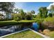 Peaceful canal view with lush greenery and reflection of the building at 1100 Martinique Dr # 208, Winter Haven, FL 33884