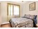 Bedroom with plaid comforter and a window with sheer curtains at 512 N 4Th St, Haines City, FL 33844