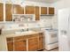 Retro kitchen features wood cabinets, white appliances, and floral tile at 512 N 4Th St, Haines City, FL 33844