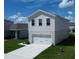 Two-story house with gray siding, a two-car garage, and a manicured lawn at 5031 Starboard St, Haines City, FL 33844