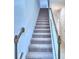 Beige carpeted staircase with light walls and wooden railing at 1476 Leamington Lane, Winter Haven, FL 33884