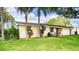 Single story home with mature palm trees and manicured lawn at 4822 Melody Ln, Lakeland, FL 33805