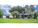 Large backyard with covered patio, lush landscaping, and a screened enclosure at 4822 Melody Ln, Lakeland, FL 33805