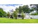 Fenced backyard with covered patio, mature trees, and grassy area at 4822 Melody Ln, Lakeland, FL 33805