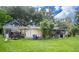 Spacious backyard with covered patio, mature trees, and ample grassy area at 4822 Melody Ln, Lakeland, FL 33805