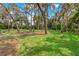 Large grassy backyard with mature trees and a fenced perimeter at 3038 Spirit Lake Dr, Winter Haven, FL 33880