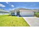 One-story home with a two car garage and front yard at 1560 Leamington Lane, Winter Haven, FL 33884
