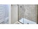 Walk-in shower with glass enclosure and grey tile at 1560 Leamington Lane, Winter Haven, FL 33884