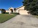 Exterior view showcasing a house with a beige facade and attached garage at 9260 Winchester Estates Blvd, Lakeland, FL 33810