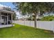 Large backyard with grassy lawn, mature tree, and white vinyl fence at 3540 Julius Estates Blvd, Winter Haven, FL 33881