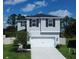 Two-story house with grey siding, white garage door, and landscaping at 1011 Overlook Ct, Davenport, FL 33837