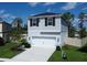 Two-story house with gray siding, white garage door, and landscaping at 1011 Overlook Ct, Davenport, FL 33837