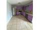 Kitchen features purple cabinets, stainless steel appliances, and tile flooring at 100 Stevenson Rd, Winter Haven, FL 33884