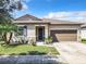 One story house with gray siding, brown garage door, landscaping at 278 Alford Dr, Davenport, FL 33896