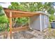 Gray storage shed with a wooden awning and pavers at 4590 San Heath Rd, Bartow, FL 33830