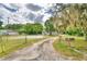 Quaint one-story house with a gravel driveway and mature trees at 4590 San Heath Rd, Bartow, FL 33830
