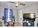 Bright bedroom with a large TV, weight bench, and ceiling fan at 4590 San Heath Rd, Bartow, FL 33830