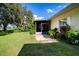 Private patio with adjacent grass lawn and tropical landscaping at 708 Canberra Rd, Winter Haven, FL 33884