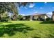 Large backyard with lush green grass and mature trees at 708 Canberra Rd, Winter Haven, FL 33884